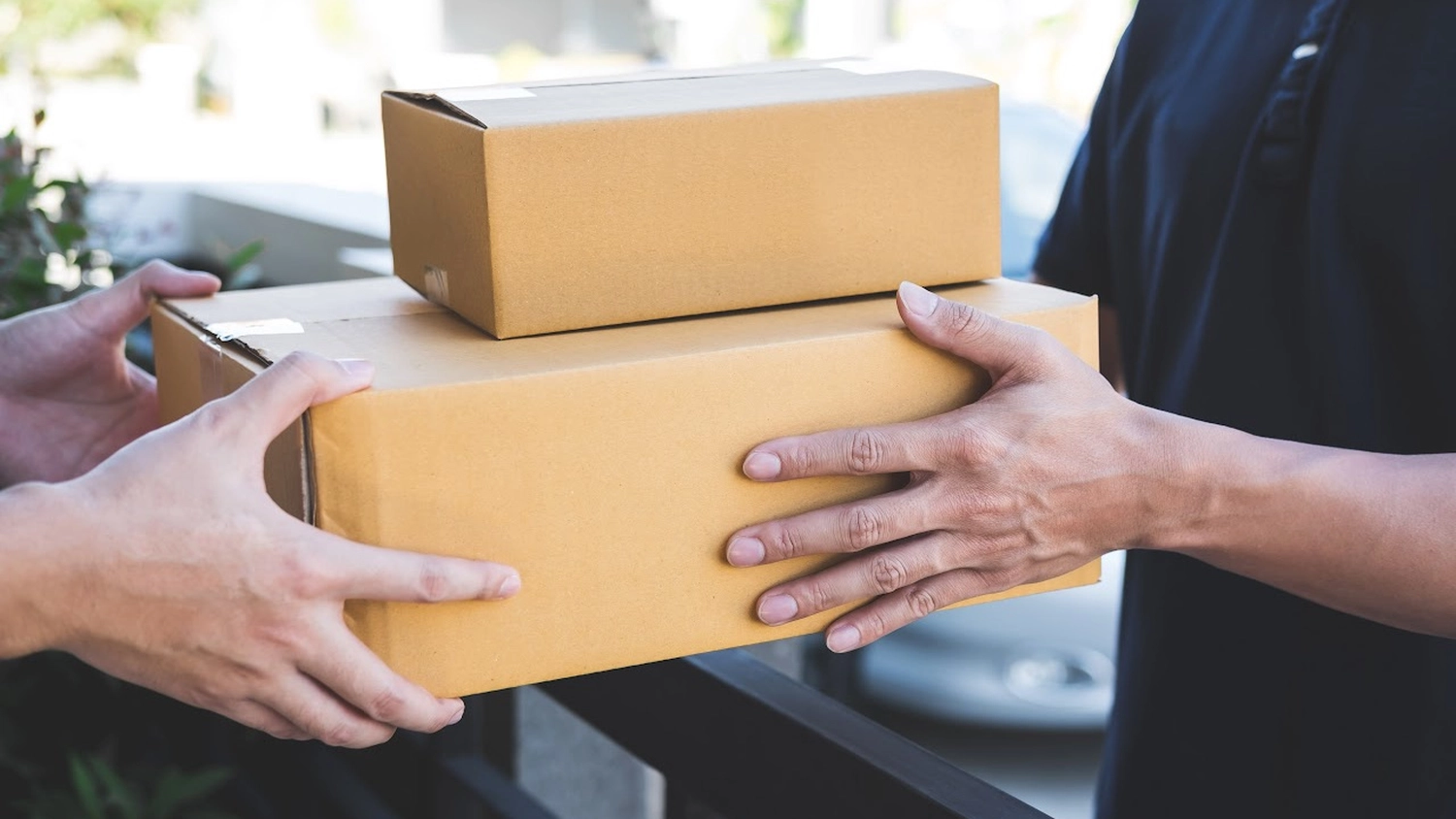 Ein Mann gibt einem anderen Mann ein Paket von Royal Fahrservice